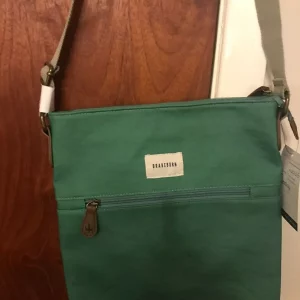 Brakeburn Green  cross body bag. two internal slip pockets, a front zip pocket